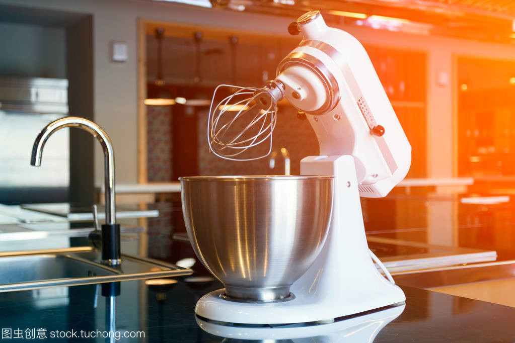 一個美麗的白色攪拌機與金屬杯站在現代廚房